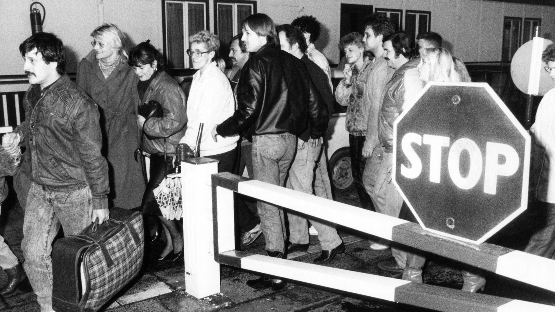 In der Nacht vom 9. auf den 10. November passieren diese Ost-Berliner vor Ihrer Einreise nach West-Berlin ein Grenzhäuschen. Nach der Bekanntgabe einer neuen großzügigen Reiseregelung für DDR-Bürger auf einer Pressekonferenz der DDR-Regierung am 09.11.1989 in Ost-Berlin fiel die innerdeutsche Grenze.