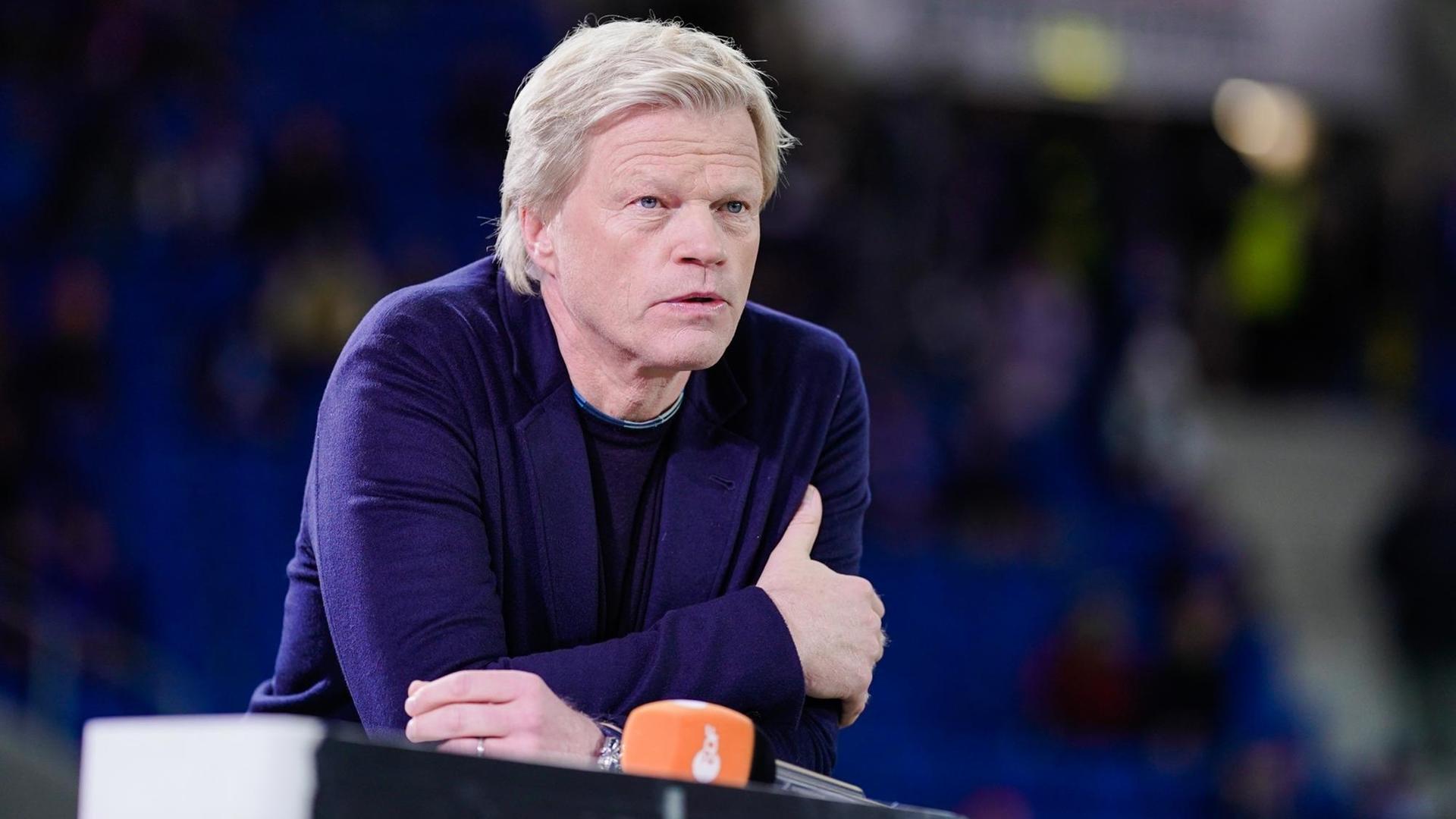 Das Foto zeigt den früheren Fußball-Profi Oliver Kahn. Er befindet sich in einem Stadion und kommentiert ein Spiel. Das Foto zeigt den früheren Fußball-Profi Oliver Kahn. Er befindet sich in einem Stadion und kommentiert ein Spiel.