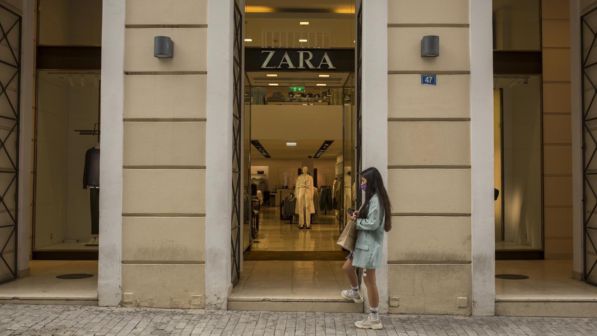 05.04.2021, Griechenland, Athen: Eine junge Frau wartet vor einem Bekleidungsgeschäft der Modekette Zara, um eintreten zu können. Von Montag, 05.04.2021 an dürfen Geschäfte in weiten Teilen Griechenlands nach wochenlangem Lockdown während der Corona-Pandemie wieder öffnen. Der Gang ins Geschäft sei allerdings mit etlichen Auflagen verbunden. Foto: Socrates Baltagiannis/dpa +++ dpa-Bildfunk +++ 05.04.2021, Griechenland, Athen: Eine junge Frau wartet vor einem Bekleidungsgeschäft der Modekette Zara, um eintreten zu können. Von Montag, 05.04.2021 an dürfen Geschäfte in weiten Teilen Griechenlands nach wochenlangem Lockdown während der Corona-Pandemie wieder öffnen. Der Gang ins Geschäft sei allerdings mit etlichen Auflagen verbunden. Foto: Socrates Baltagiannis/dpa +++ dpa-Bildfunk +++
