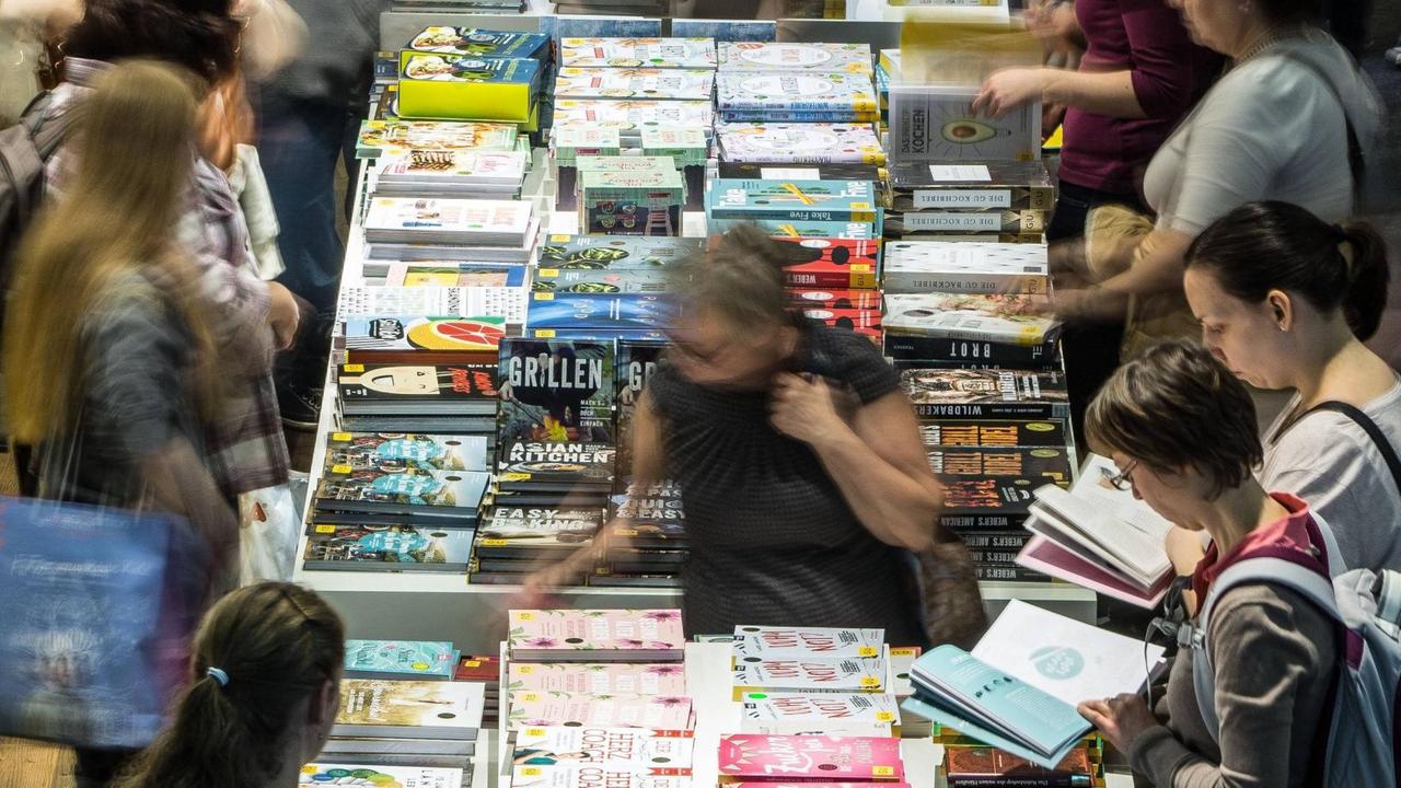 Menschen stehen vor einem Büchertisch auf der Frankfurter Buchmesse