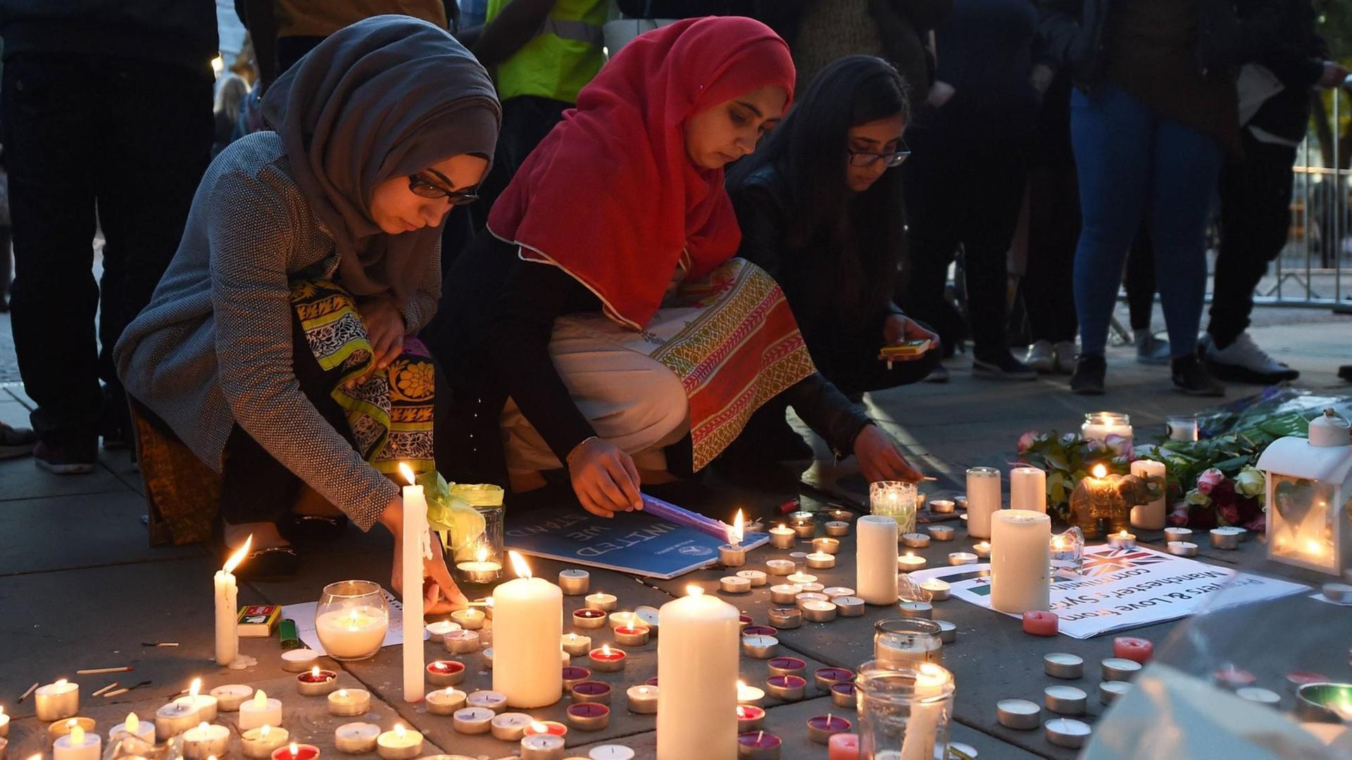 Menschen gedenken auf dem Albert Square in Manchester der Opfer des Anschlags auf ein Popkonzert. Kurz zuvor war ein 23-jähriger Mann festgenommen worden.