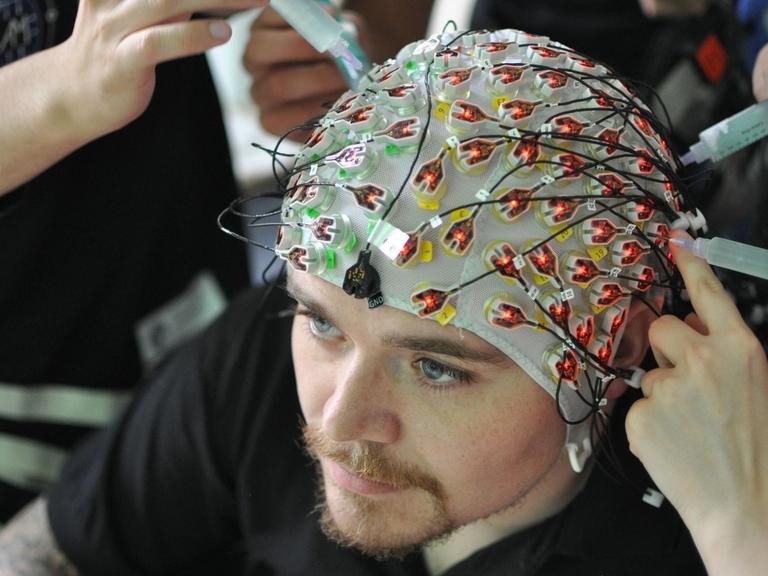 In den Gehirnströmen verbergen sich Muster. Um die für das Computersystem erkennbar zu machen, müssen 129 Elektroden einzeln gegelt und an der Kopfhaut angebracht werden