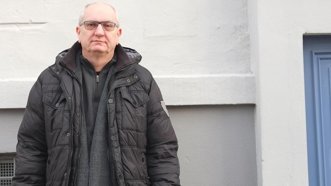 Gerhard Zawatzki steht vor draußen vor einer weißen Wand. Der IT-Spezialist half nach dem Anschlag auf dem Berliner Breitscheidplatz Verletzten. Die Erlebnisse haben ihn arbeitsunfähig gemacht.