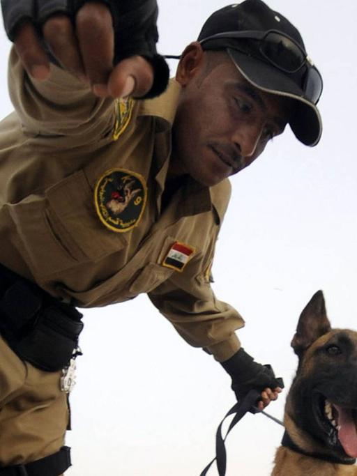 Ein irakischer Grenzsoldat mit einem Hund.
