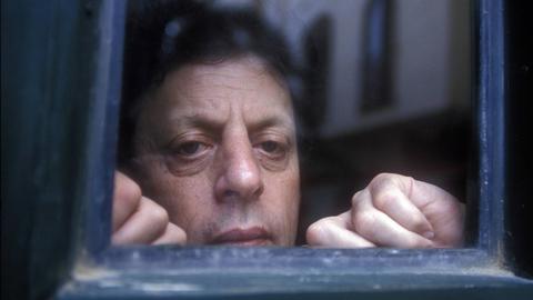 Künstlerisches Foto mit dem Komponisten Philip Glass (Kopf) hinter einem antiken blauen Glasfenster um 1994