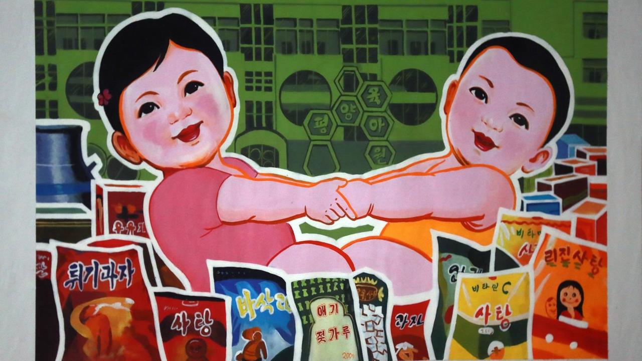 Ein buntes Poster mit Agitationssprüchen in der Ausstellung "Made in North Korea" im Ultra Modern Art Museum in Moscow.