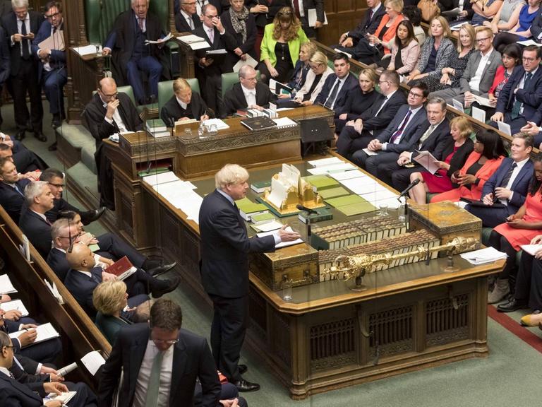 Blick ins britische Unterhaus. Die Abgeordneten sitzen in den grünledernen Bänken, während Premierminister Boris Johnson eine Rede hält.