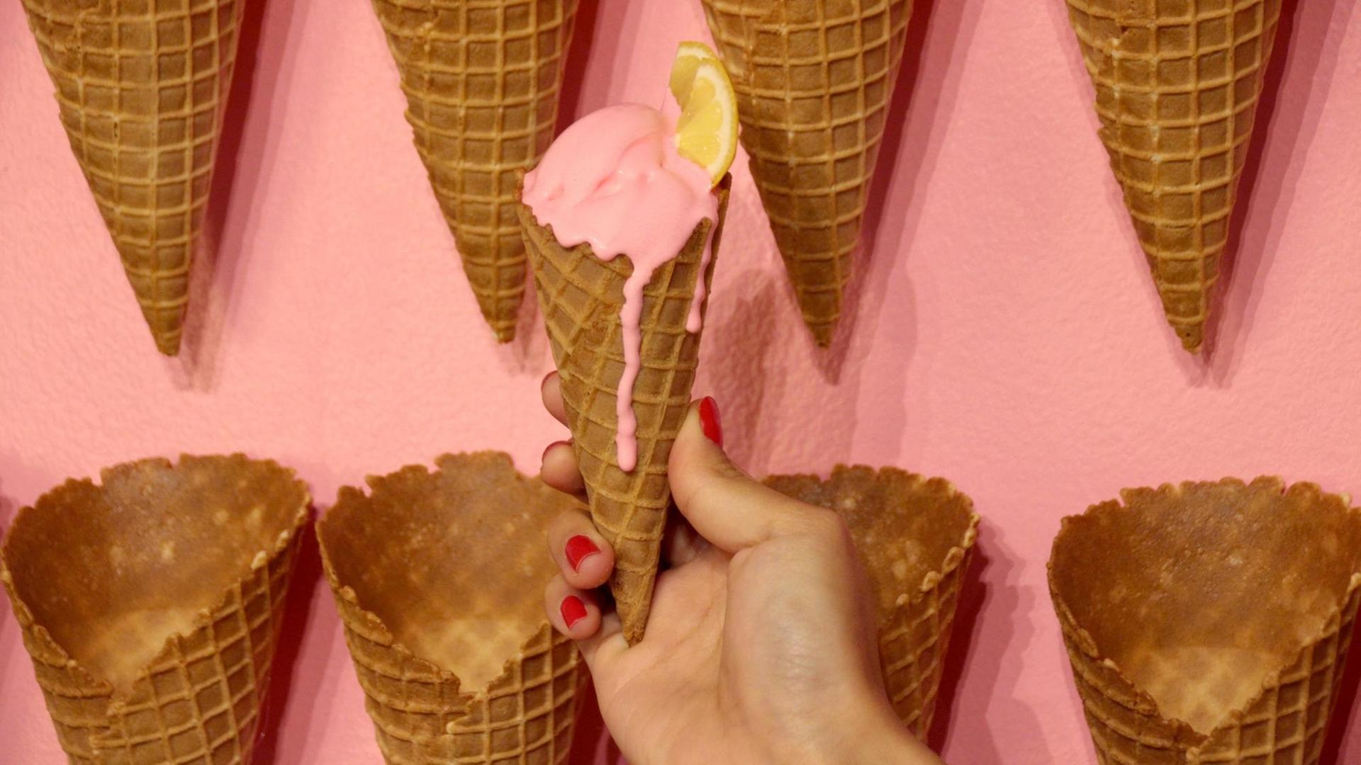 Ausstellungsstücke in Form von Eistüten hängen im Museum of Ice Cream in New York (USA) an einer Wand.