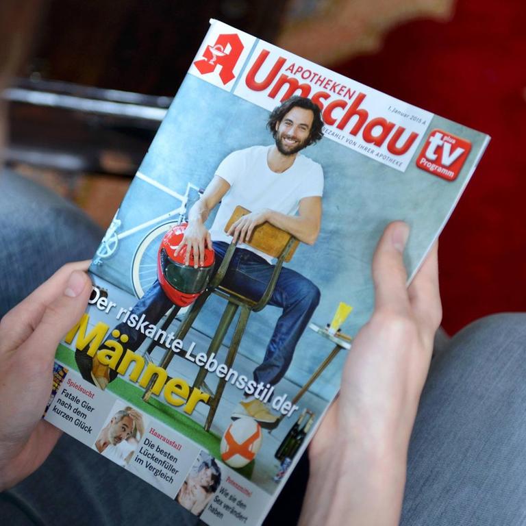 Ein Mann hält eine Ausgabe der "Apotheken Umschau" auf den Knien und schaut auf die Titelseite.