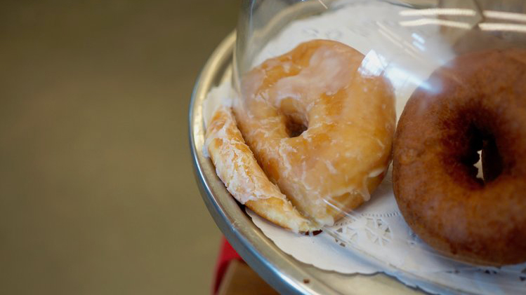 Was haben Donuts mit Depressionen zu tun. Für Tara Wray sind die Teigteilchen unter der Glashaube Ausdruck ihrer Niedergeschlagenheit.