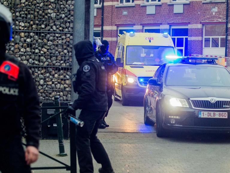 Ein Polizeiwagen und ein Krankenwagen fahren von dem Ort weg, an dem der mutmaßliche Paris-Attentäter Salah Abdeslam gestellt und verletzt worden sein soll.