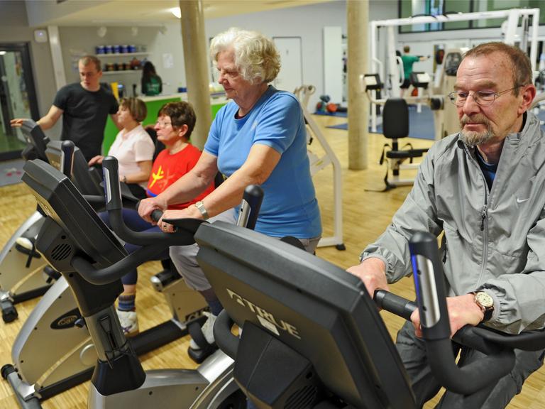 Vier Senioren trainieren am 23.01.2014 in Kassel (Hessen) auf dem Ergometer.