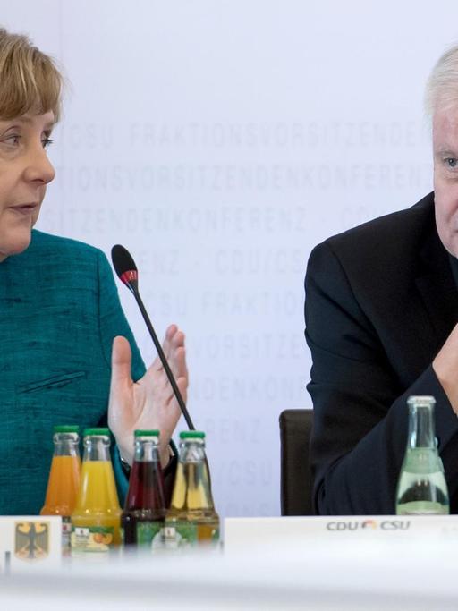 Bundeskanzlerin Angela Merkel (CDU) und der bayerische Ministerpräsident Horst Seehofer (CSU) sitzen während der Fraktionsvorsitzendenkonferenz von CDU und CSU