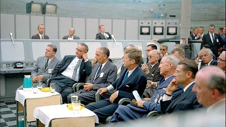 Kurt Debus 1963 zusammen mit US-Präsident John F. Kennedy und Vizepräsident Lyndon B. Johnson in einem Kontrollraum des Kennedy Space Center