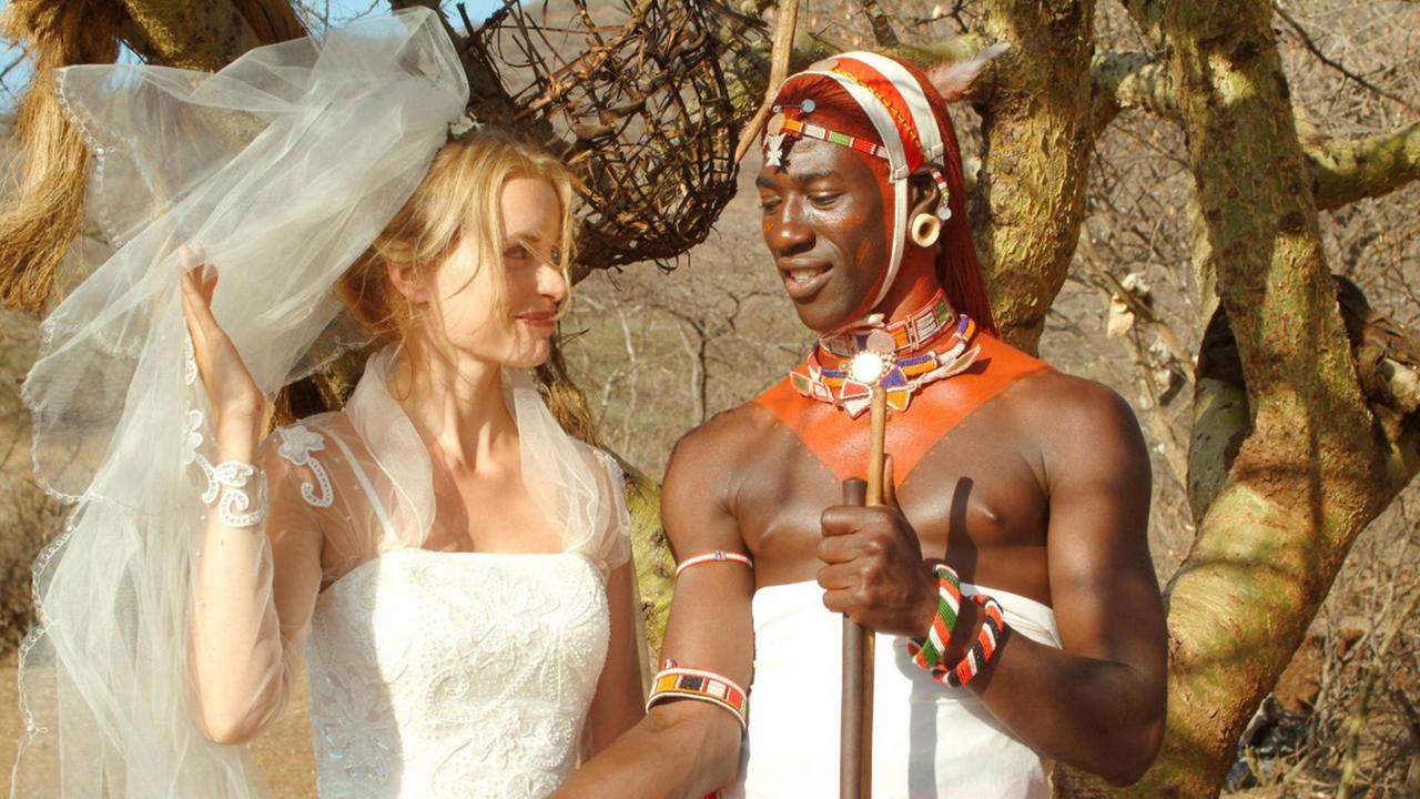 Ein Filmstill aus "Die Weiße Massai" aus dem Jahr 2005 zeigt Nina Hoss im Brautkleid und Jacky Ido als Afrikaner in traditioneller Tracht.