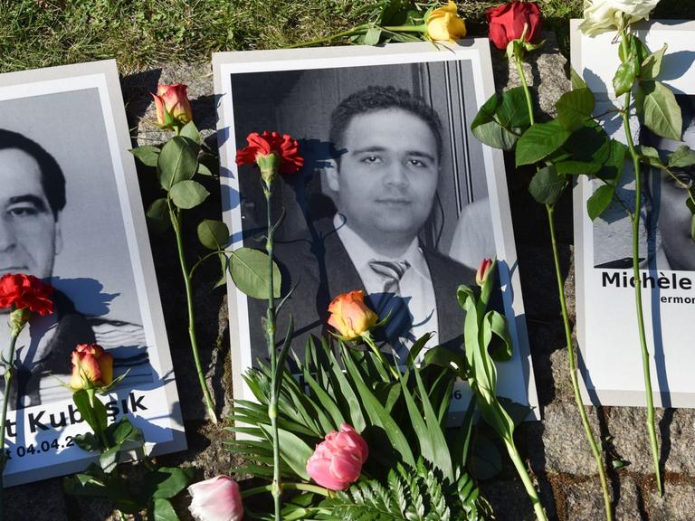 Blumen liegen am Halitplatz neben Porträts des 2006 in Kassel ermordeten Halit Yozgat und anderen Opfern des NSU. Die Stadt Kassel hatte offiziell die Gedenkveranstaltung für Halit Yozgat wegen Sicherheitsbedenken abgesagt. Rund 300 Trauernde versammelten sich am Platz rund um den Gedenkstein.