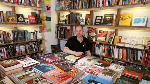 Hansjörg Ebert, Inhaber der Comic-Buchhandlung "Strips & Stories", sitzt am 13.08.2014 in Hamburg zwischen den Büchern seines Geschäfts.