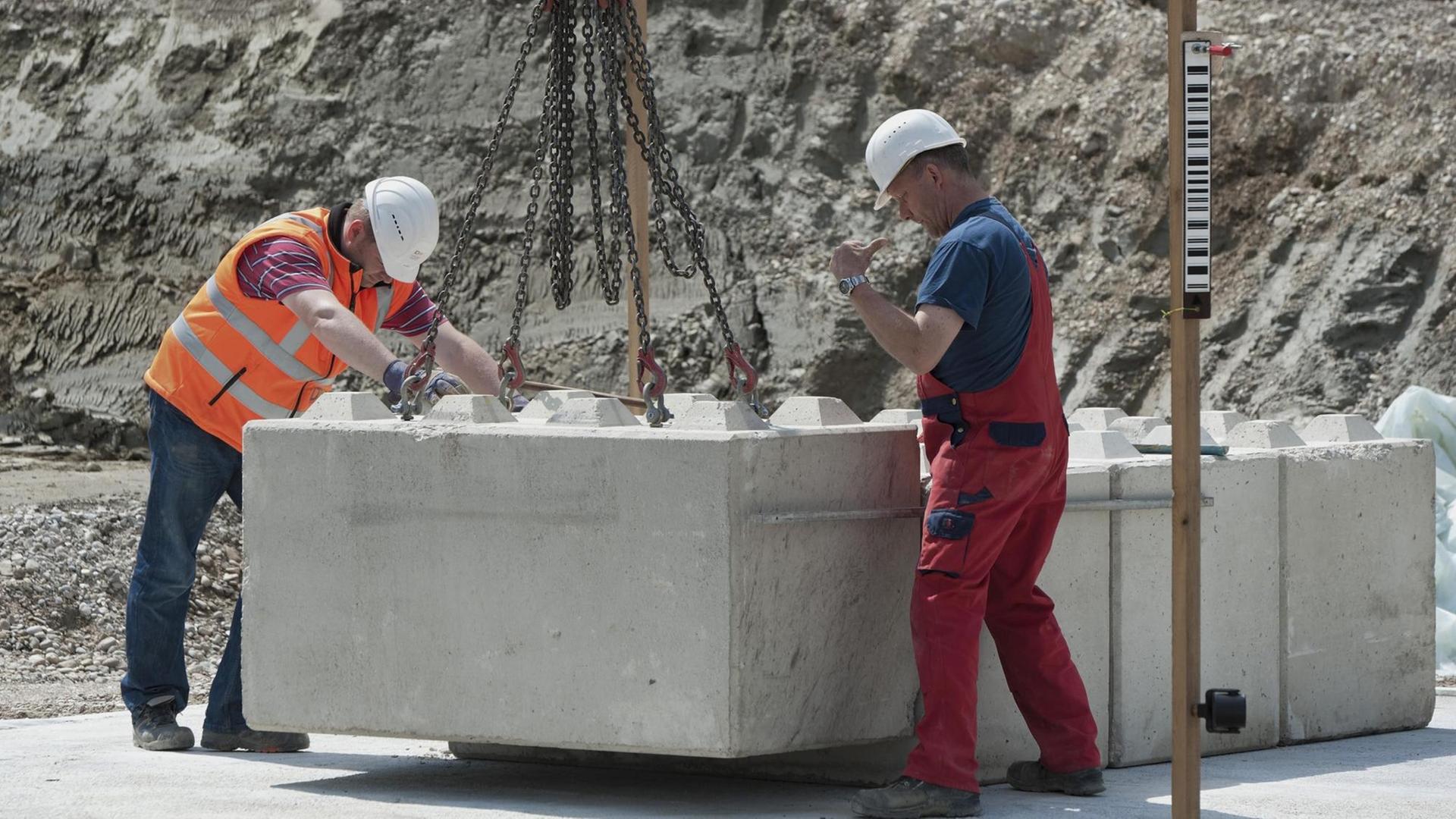Bauingenieure setzen erste Steine für eine Baugrund-Probebelastung auf einer Baustelle. Bauingenieure setzen erste Steine für eine Baugrund-Probebelastung auf einer Baustelle.