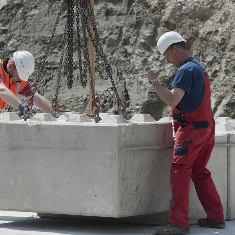 Bauingenieure setzen erste Steine für eine Baugrund-Probebelastung, auf einer Baustelle in Fridolfing, Bayern