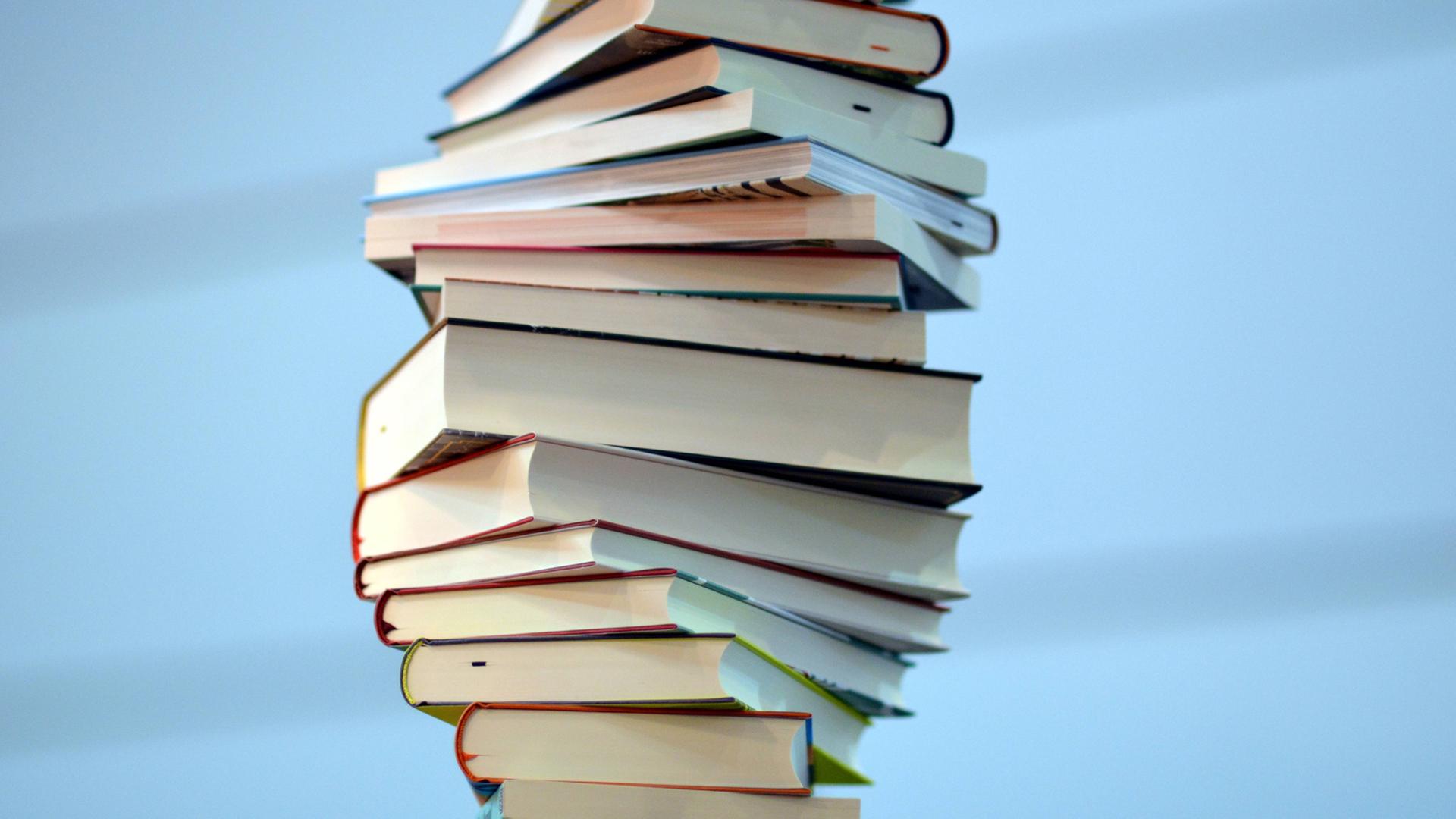 Bücher sind zu einem unebenen Stapel aufgetürmt.