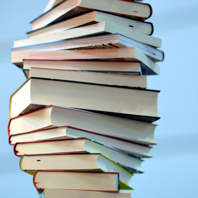 Bücher sind zu einem unebenen Stapel aufgetürmt.