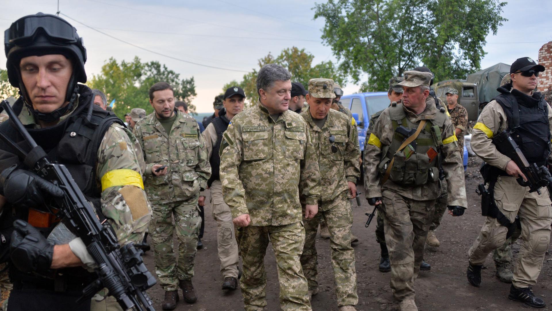 Der ukrainische Präsident Petro Poroschenko begleitet mit einer Militäruniform bekleidet ukrainische Soldaten während eines Besuches im Armee-Hauptquartier nahe der Stadt Izyum am 08.07.2014.