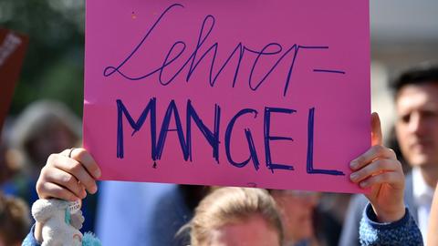 Eine Schülerin hält ein Plakat mit der Aufschrift "Lehrermangel" bei einer Demonstration am 01.06.2017 vor dem Thüringer Landtag in Erfurt (Thüringen) in den Händen.