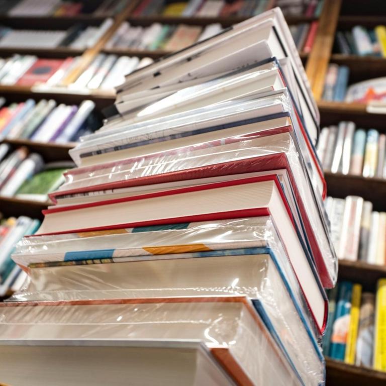 Ein Stapel neuer Bücher liegt auf einem Verkaufstisch in einer Buchhandlung 