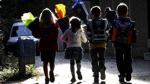 Vier Kinder mit Schultüten auf dem Weg zur Einschulung