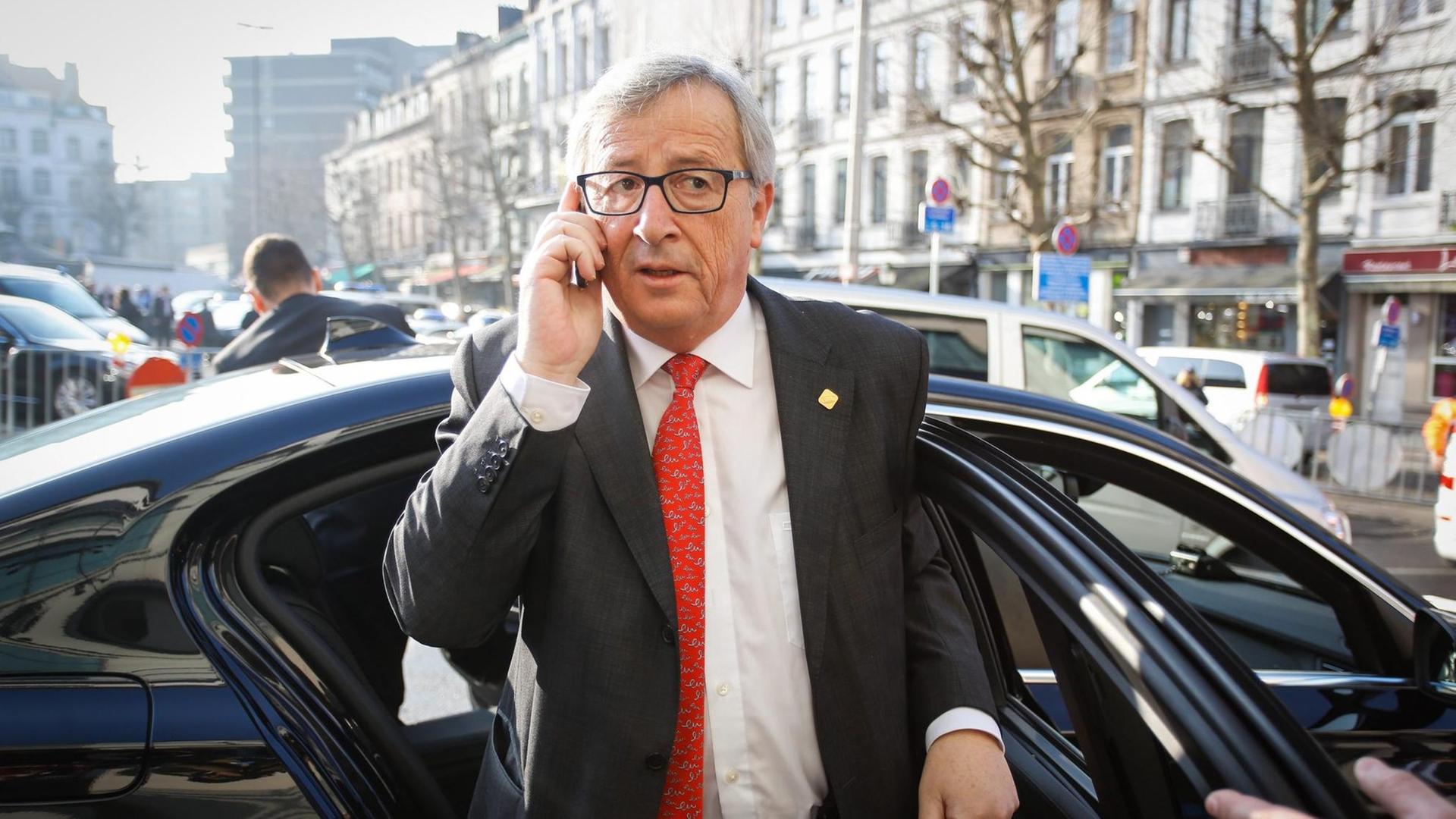 EU-Kommissionspräsident Jean-Claude Juncker steigt vor einem Gipfel in Brüssel mit dem Handy telefonierend aus dem Auto aus.