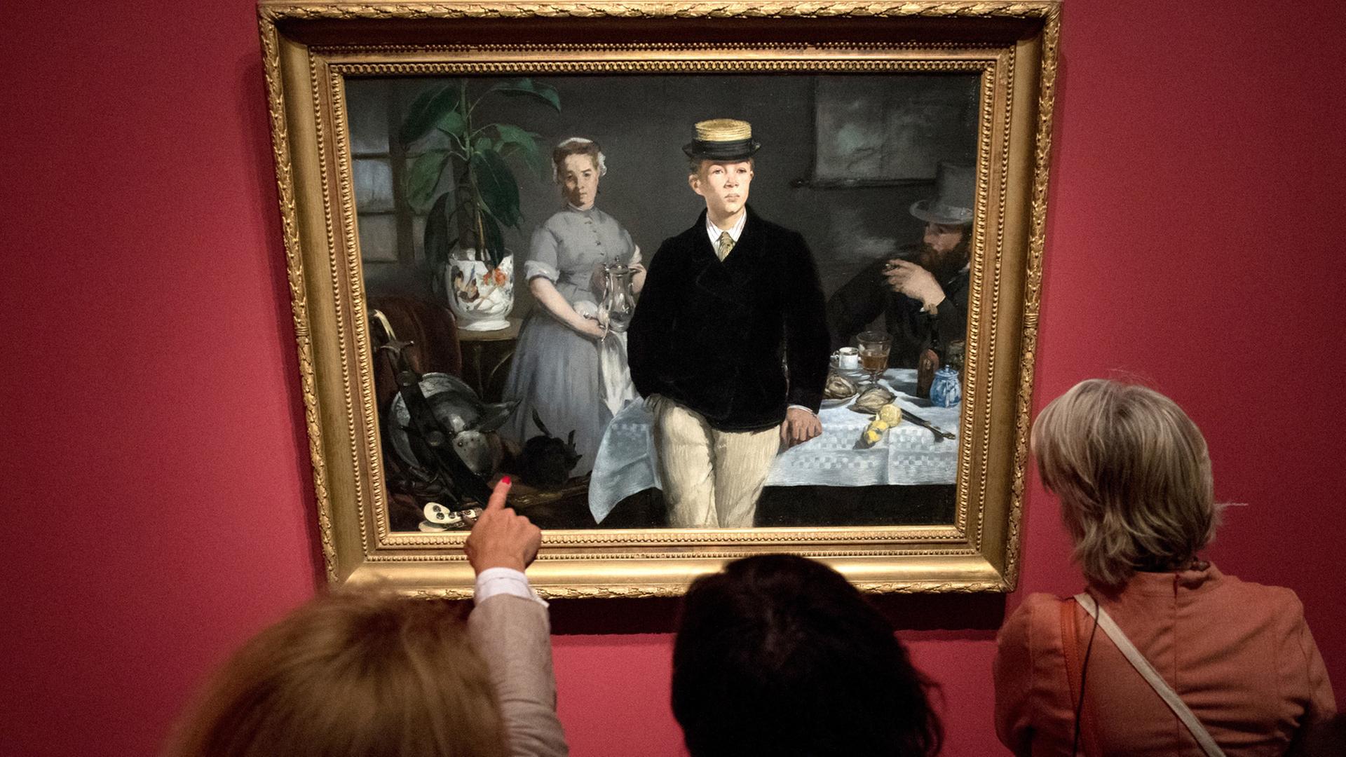 Drei Frauen betrachten in der Hamburger Kunsthalle das Bild "Das Frühstück im Atelier" des Künstlers Edouard Manet. Die Ausstellung "Manet - Sehen. Der Blick der Moderne" wird vom 27. April bis zum 4. September.2016 in der Hansestadt gezeigt.