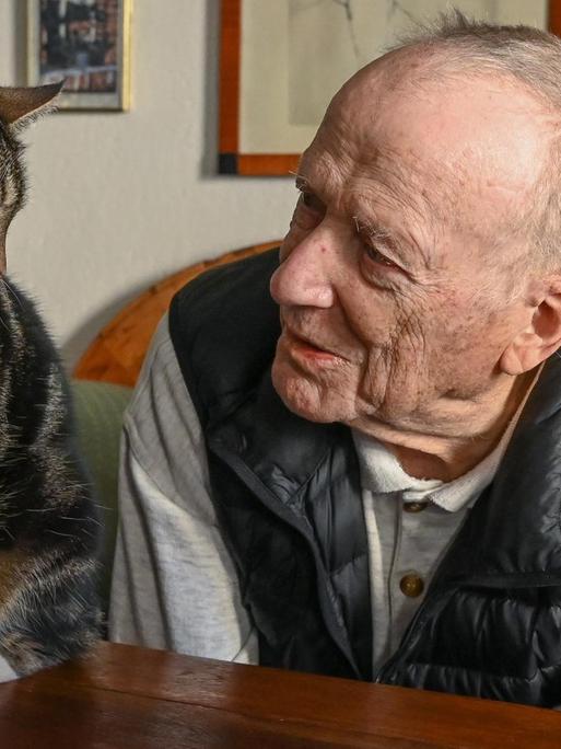 Der 90-jährige Drehbuchautor Wolfgang Kohlhaase betrachtet freundlich eine Katze.