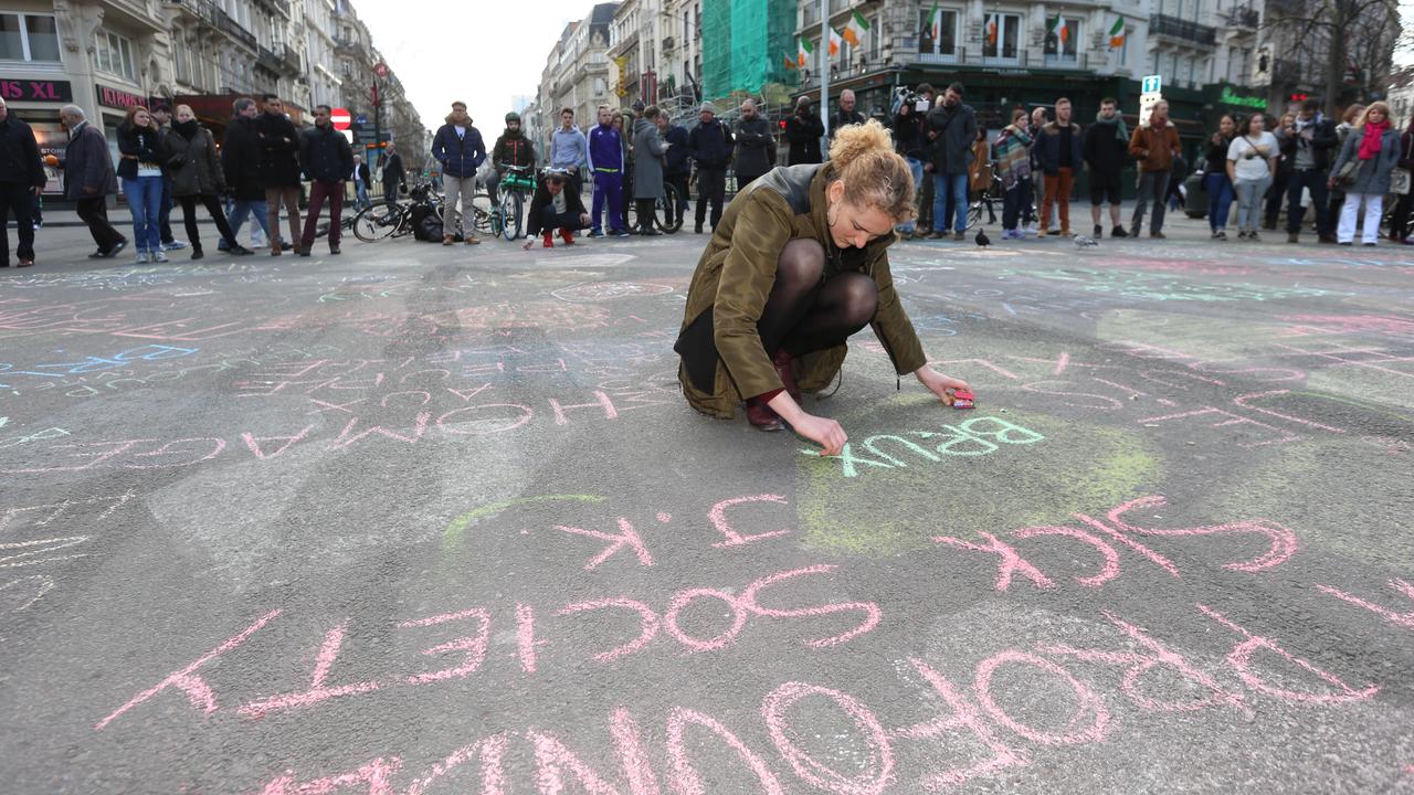 Eine Frau schreibt eine Nachricht auf einen Platz in der Innenstadt von Brüssel.