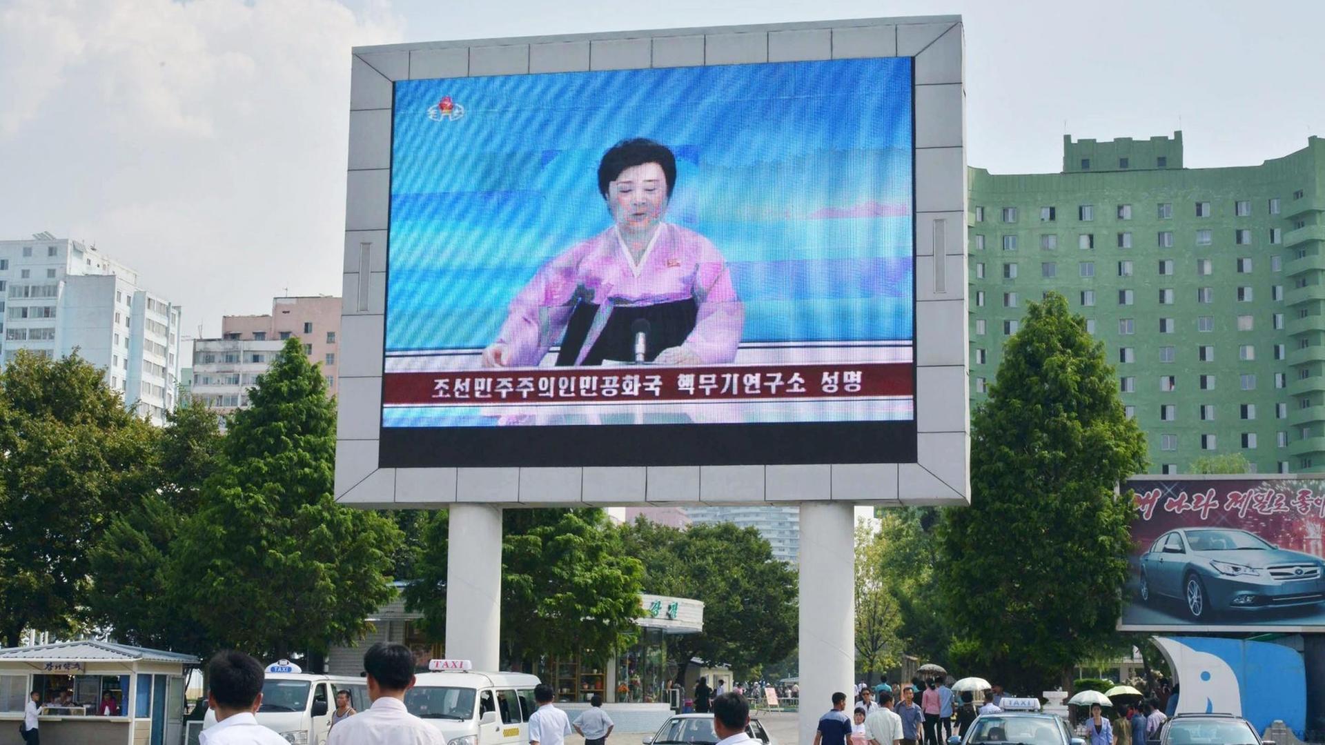 Auf einem großen Bildschirm vor der Pjöngjang Station ist eine Sprecherin des staatlichen Fernsehens zu sehen, die über den fünften Atom-Test Nordkoreas berichtet.