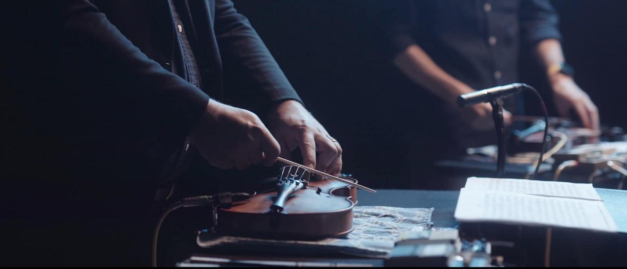 Zwei liegende Geigen werden von den Spielern mit Schlaghölzern gerieben