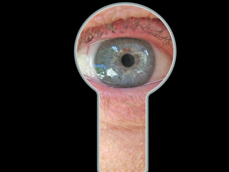 Ein Auge blickt durch eine Schlüsselloch.