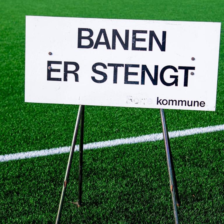 Ein Schild, das auf die Schließung hinweist, steht im März auf einem Fußballfeld im norwegischen Horten.