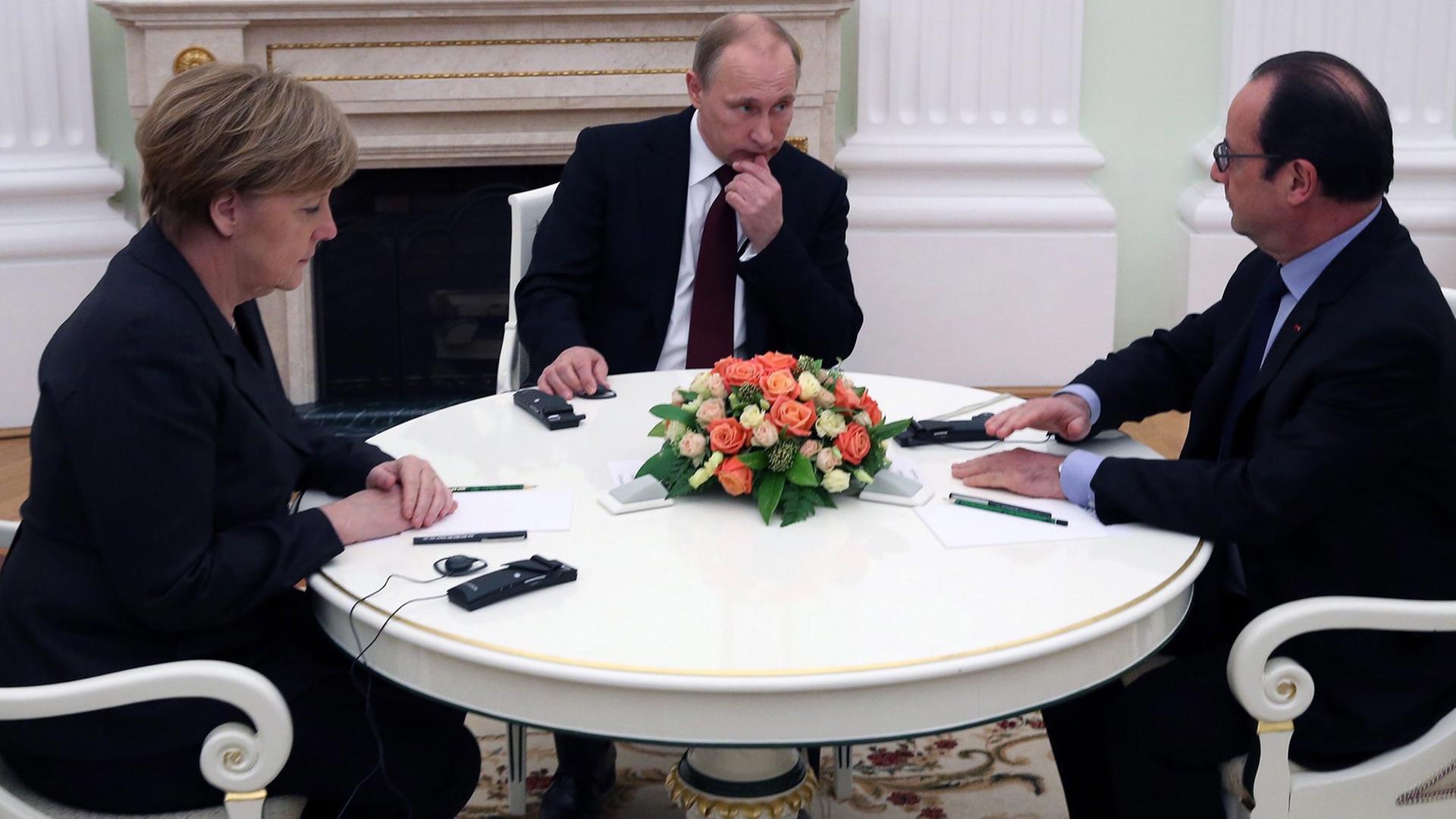 Angela Merkel, Francois Hollande und Wladimir Putin an einem Tisch im Kreml.