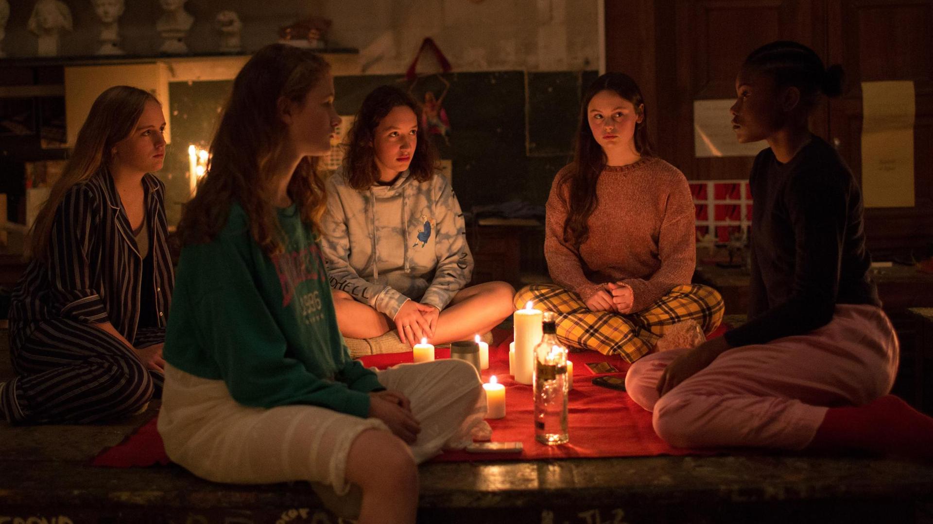 Filmstill aus "Zombi Child" von Bertrand Bonello: Teenagermädchen treffen sich bei Kerzenschein und Alkohol.
