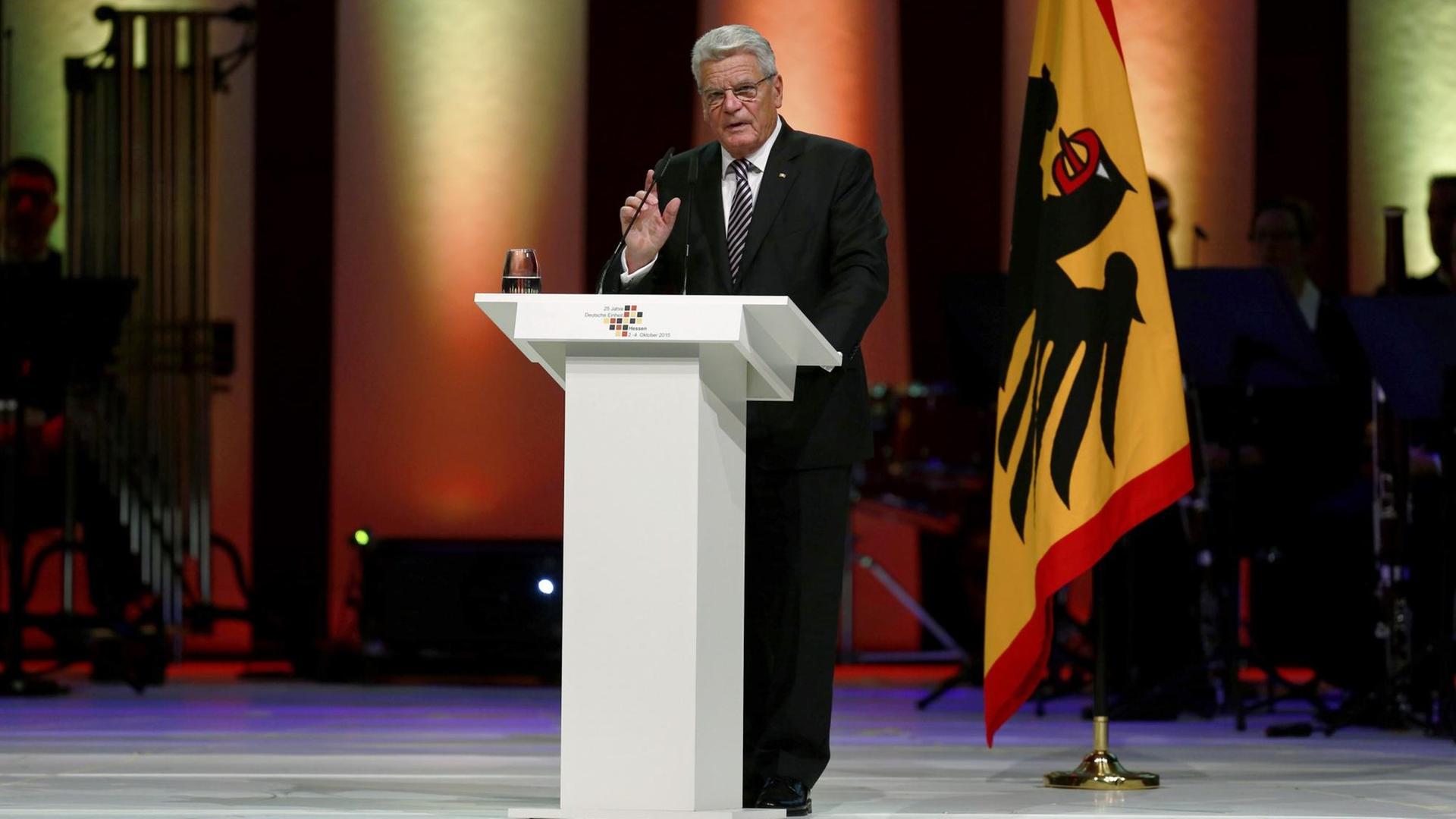 Bundespräsident Joachim Gauck steht hinter einem Sprecherpult und hält eine Rede. Im Hintergrund ist die Standarte des Bundespräsidenten zu sehen.
