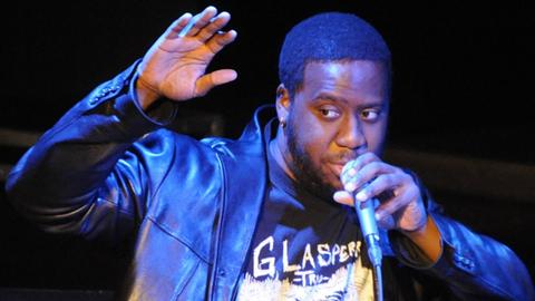 Robert Glasper singt in ein Mikrofon.
