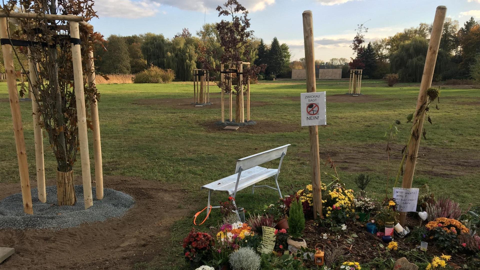 Blumen und Kerzen liegen vor der zerstörten Gedenkstätte in Zwickau