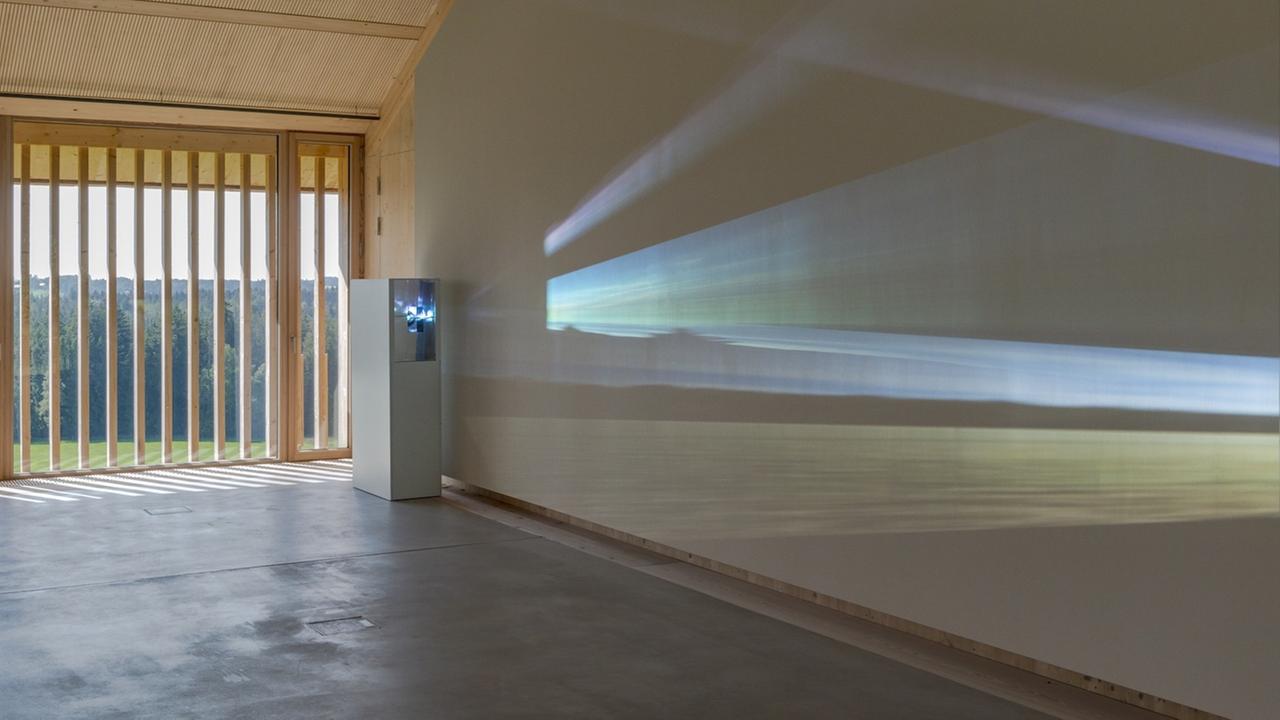 Die Installation "re_FLEX_ionen" von Mischa Kuball in Nantesgut projeziert Farben der Landschaft draußen an eine Wand im Raum