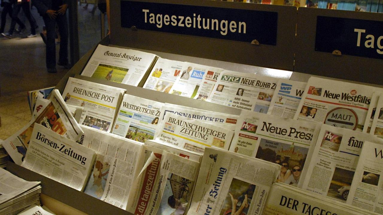 Auf einem Verkaufsstand liegen etliche verschiedene Tageszeitungen in der Auslage.