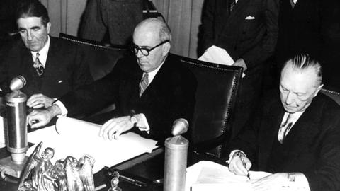 Hochkommissar John McCloy und Bundeskanzler Konrad Adenauer unterzeichnen am 15. Dezember 1949 den Marshallplan genannten ERP-Vertrag