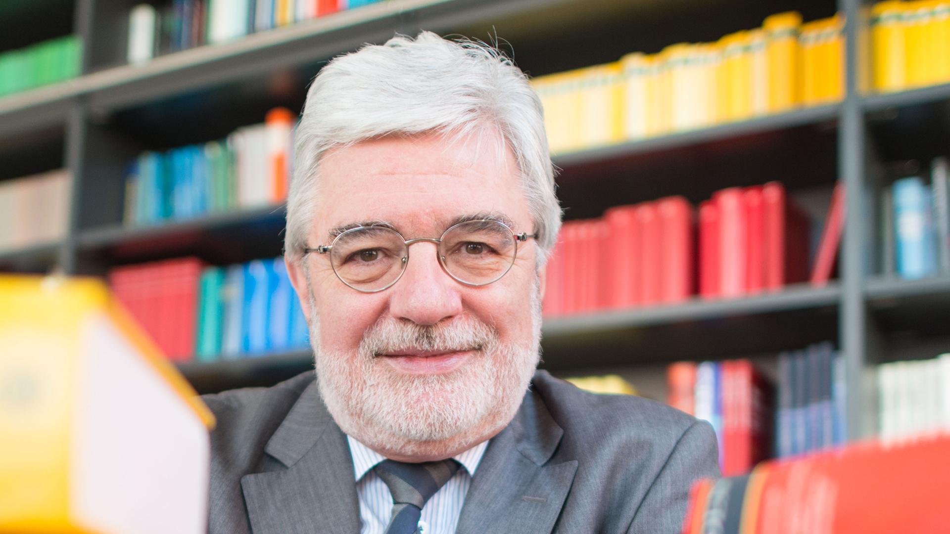 Der Direktor des Instituts für Deutsche Sprache (IDS), Ludwig M. Eichinger, sitzt am 06.03.2014 in Mannheim (Baden-Württemberg) in seinem Büro hinter einem Stapel Bücher