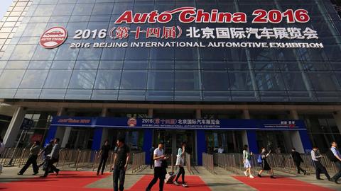 Besucher vor dem Eingang der Automobilmesse in Peking, China.