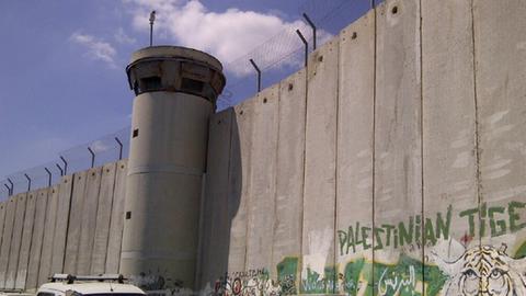 Eine Grenzmauer in Israel mit Wachturm.