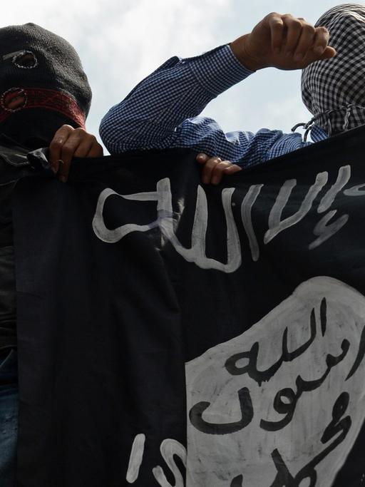 Unterstützer der Extremistenmiliz Islamischer Staat (IS) mit Fahne.