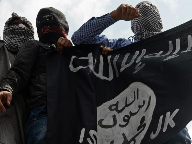 Unterstützer der Terrorgruppe Islamischer Staat (IS) mit Fahne.